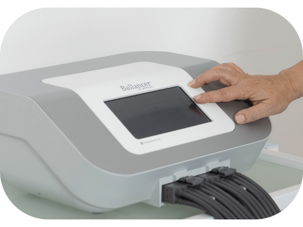 A close-up shot of a device being used on skin, featuring a transparent orange suction cap attached to a white handheld machine. The image provides a detailed view, focusing on the interaction between the device and the skin.